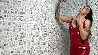 Latex fetish. Dominatrix Nika in a latex dress takes a shower. Watch as the drops of water cover Mistress's body